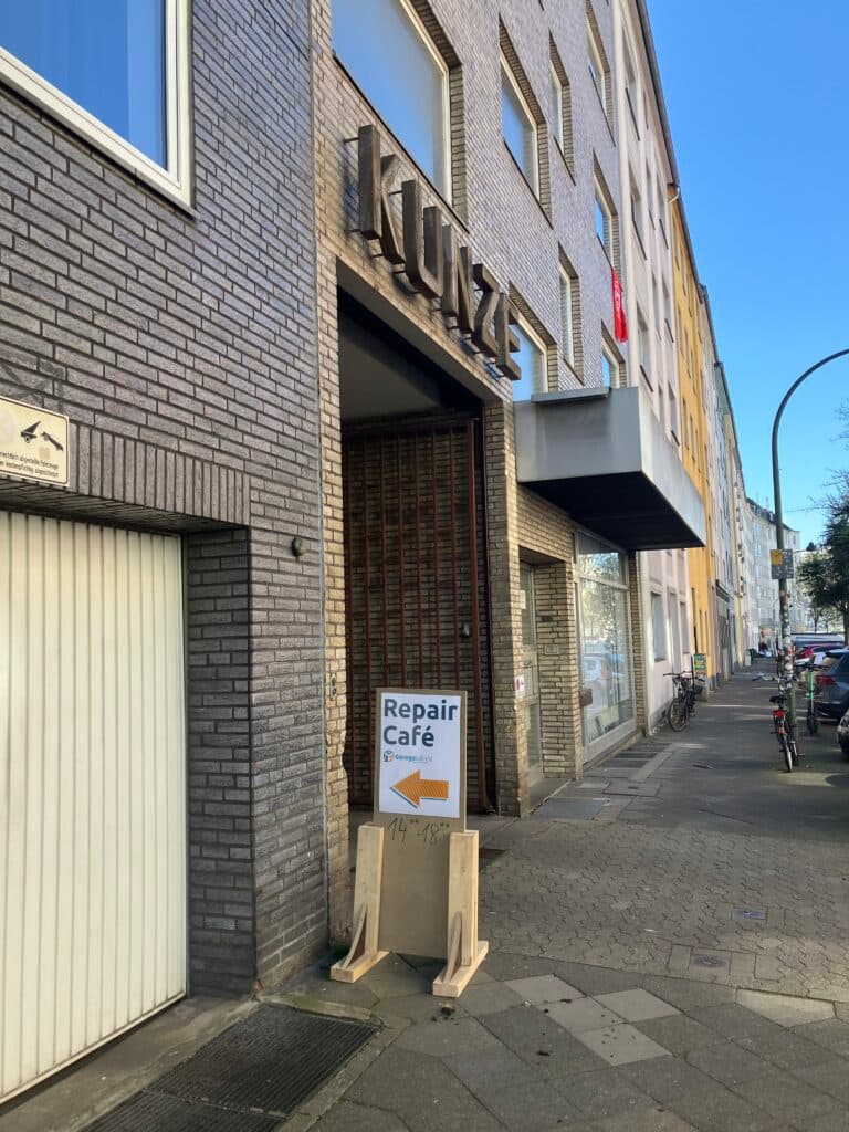 Toreinfahrt mit Schild "Reparcafé"